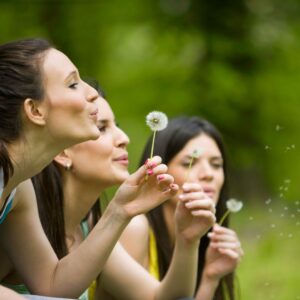 women, blowing dandelions